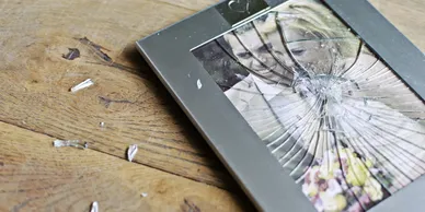 Broken picture frame symbolizing investigations of suspected infidelity and relationship issues.